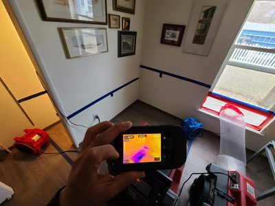 associate using a thermal imaging device to find water damage