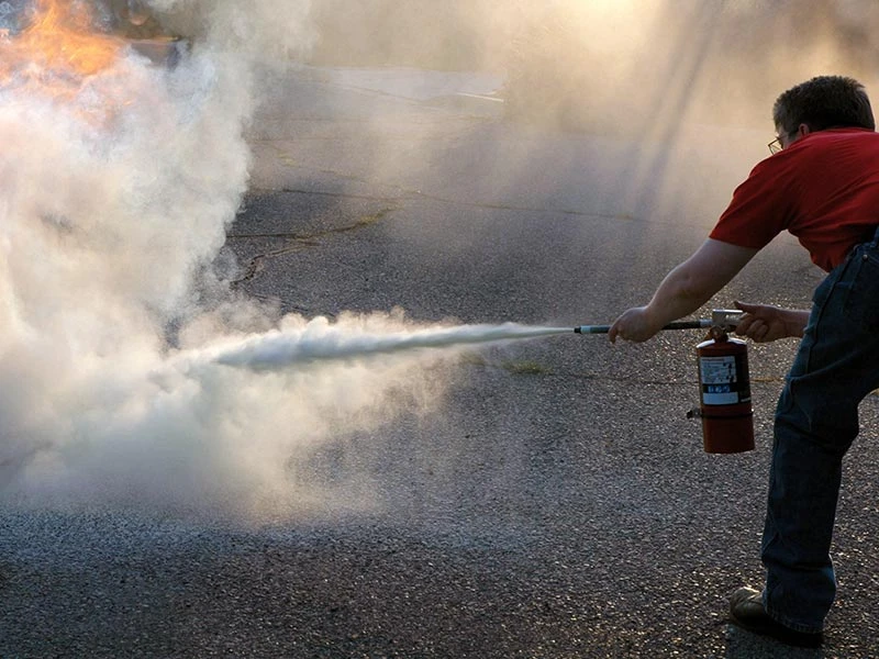 homeowner putting out an electrical fire with an extinguisher