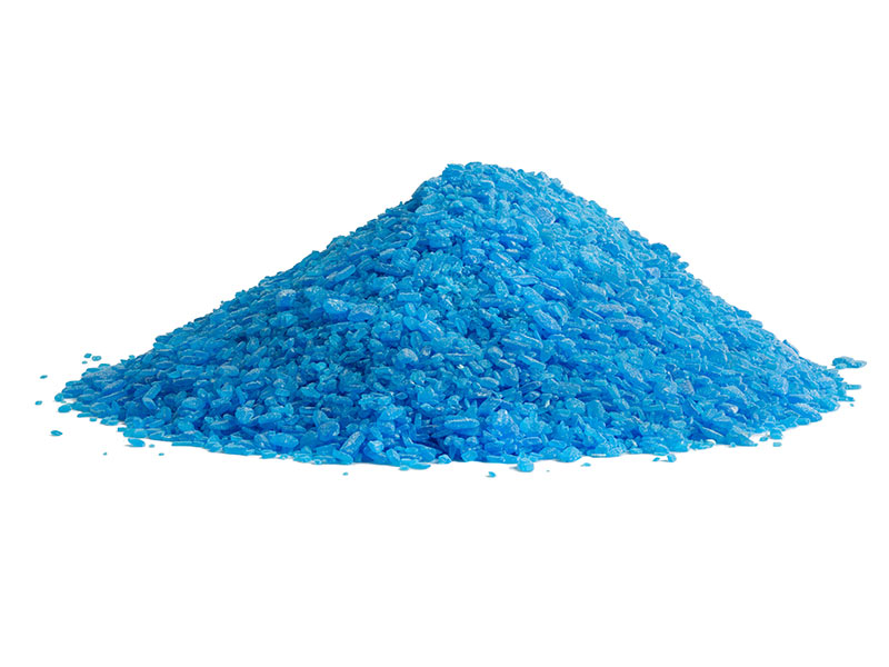 pile of blue copper sulfate granules - close-up isolated on white background