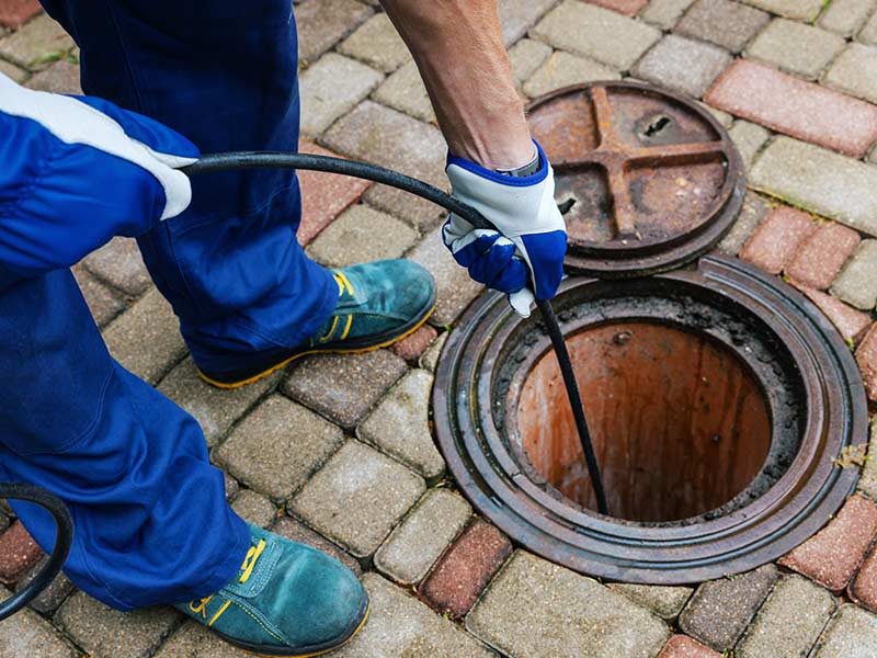 sewer cleaning service - worker clean a clogged drainage with hydro jetting