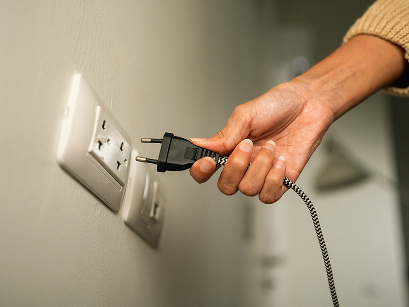 woman-unplugging-electrical-cord