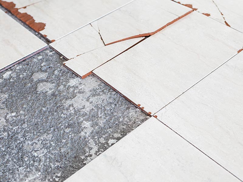 Damaged floor tiles with asbestos underneath