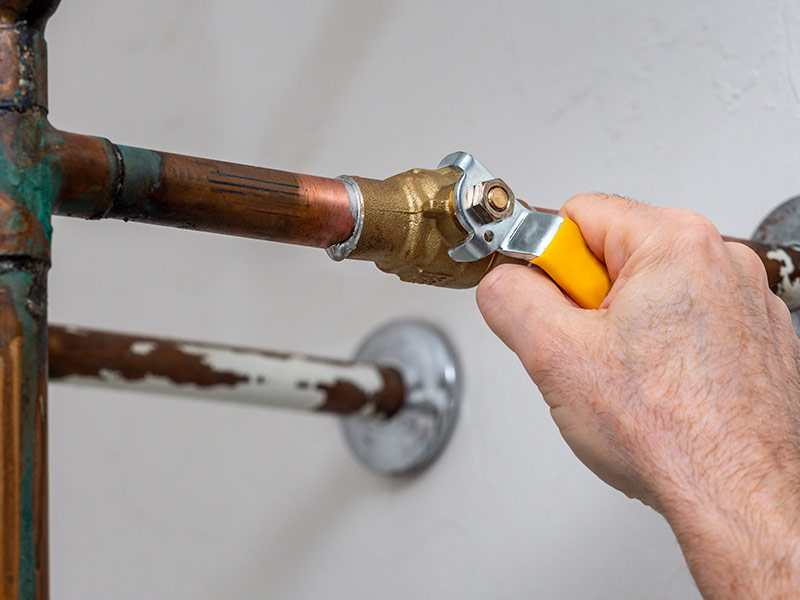 Plumber turning water shut off valve.
