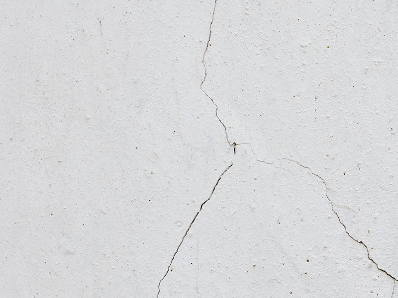 white plaster wall starting to crack from water