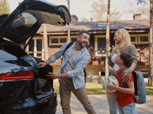 family packing their car for summer vacation