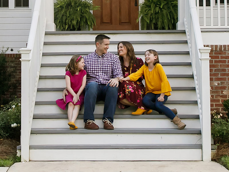 family sitting on front steps
