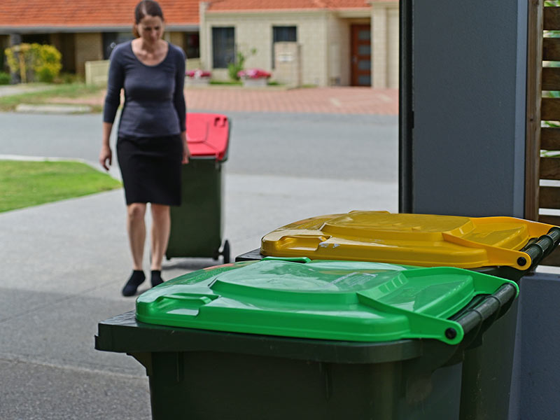 neighbor bringing in trash bins