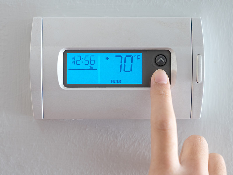 homeowner setting thermostat before vacation