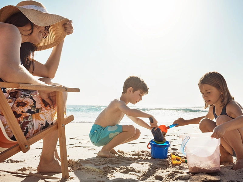 Mom, children and castle at beach